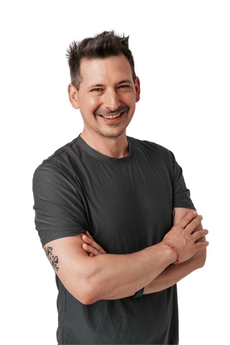 Jordon Taylor smiling at the camera with arms crosssed in a grey shirt.